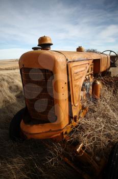 Tumbleweeds piled against abandoned tractor