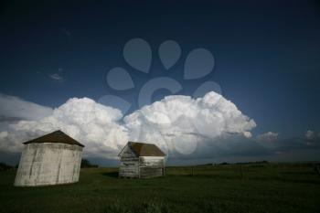 Storm clouds behind old Saskatchewan granaries