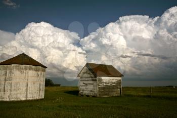 Storm clouds behind old Saskatchewan granaries