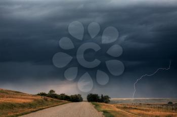 Storm clouds and lightning along a Saskatchewan country road