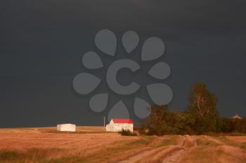 Storm clouds behind a Saskatchewan farmyard