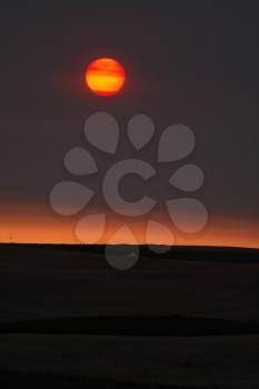 Rising sun behind thin clouds in scenic Saskatchewan