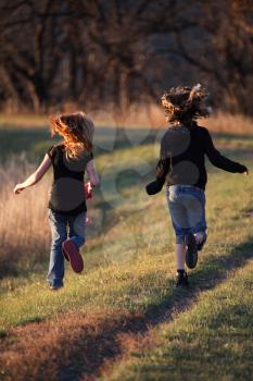 Two girls running along causeway in scenic Saskatchewan