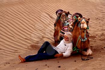 douze,tunisia,camel and people in the sahara's desert