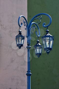 a blue street lamp  and a green white  wall in la boca buenos aires argentina