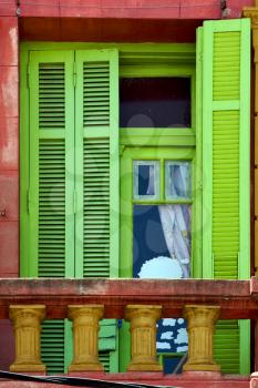 light green wood venetian blind and a red terrace  wall in la boca buenos aires argentina