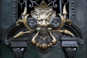brass brown knocker in a closed green wood  door buenos aires argentina

