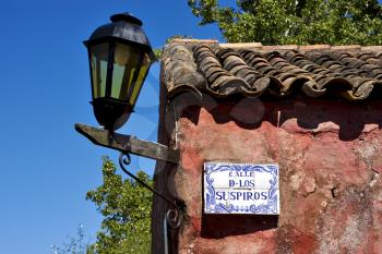 a street lamp plate plant and a wall in calle de los suspiros of house in colonia del sacramento  uruguay