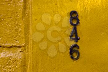  old black numbers  in a yellow wall in the centre of buenos aires argentina