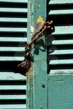 light green wood venetian blind and a rusty chain in la boca buenos aires argentina