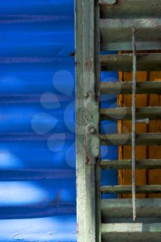 green iron venetian blind and a blue metal wall in la boca buenos aires argentina