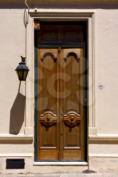 brown wood old door and a street lamp in the centre of colonia del sacramento uruguay
