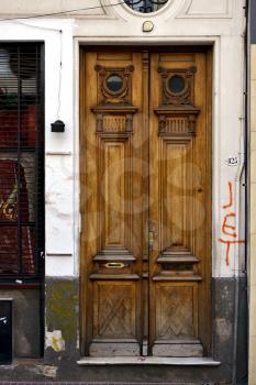 a brown wood old door and a grate in the centre of buenos aires argentina 