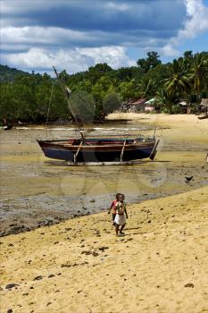 boat sand lagoon house child and coastline in madagascar nosy be