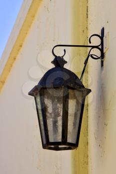 a street lamp  and a yellow wall  in calle de los suspiros in colonia del sacramento  uruguay