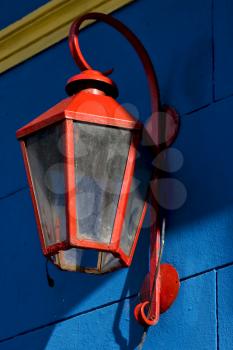 a red street lamp  and a blue yellow  wall in la boca buenos aires argentina
