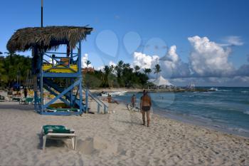 lifeguard chair cabin in republica dominicana  rock stone sky cloud people coastline and summer 
