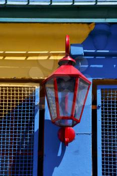   red street lamp  and a colorated  wall in la boca buenos aires argentina