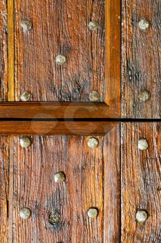 in  italy  patch lombardy    cross castellanza blur   abstract   rusty brass brown knocker  a  door curch  closed wood
