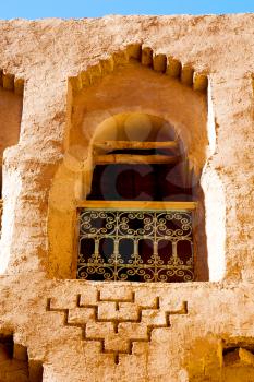 orange window in morocco africa old construction and brown wall red carpet  