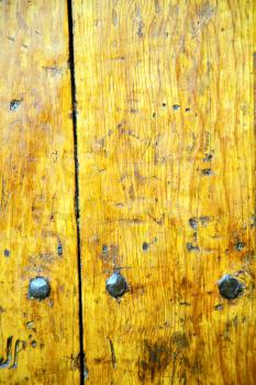 stripped paint in the blue  wood door and rusty   nail