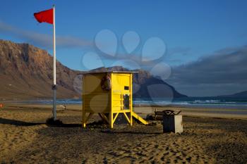 lifeguard chair red flag in spain  lanzarote  rock stone sky cloud beach  water  musk pond  coastline and summer 
