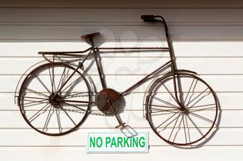  a no parkin signal in the garage door    and antique bicycle hanging 