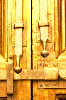 brown iron safety lock in a closed wood  door in naples italy