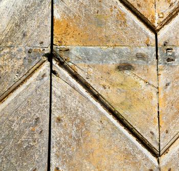  cross lombardy   arsago seprio abstract   rusty brass brown knocker in a  door curch  closed wood italy