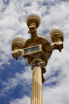 a gold street lamp  and a cloudy sky  in buenos aires argentina