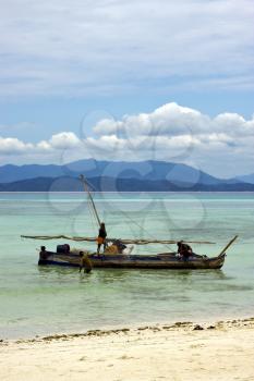 people  boat palm  rock stone branch hill lagoon and coastline in madagascar nosy be