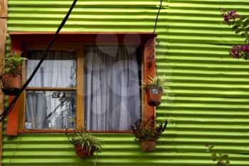 orange wood window and a green metal wall in la boca buenos aires argentina
