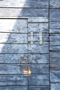 abstract cross santo antonino  brass brown knocker in a   closed wood door   varese italy