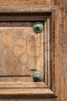 abstract   rusty brass brown knocker in a  door curch  closed wood lombardy italy  varese lonate pozzolo
