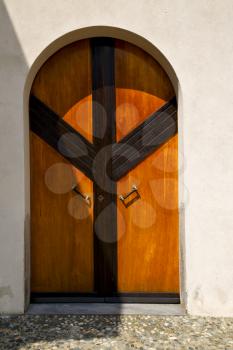 abstract cross   brass brown knocker glass in a   closed wood door  albizzate varese italy
