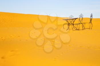 table and seat in desert sahara morocco africa yellow sand