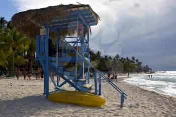lifeguard chair cabin in republica dominicana  rock stone sky cloud people coastline and summer 
