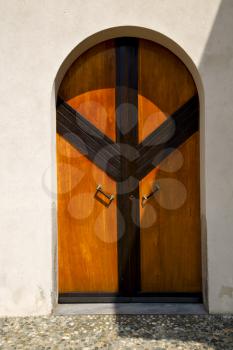 abstract cross   brass brown knocker glass in a   closed wood door  albizzate varese italy
