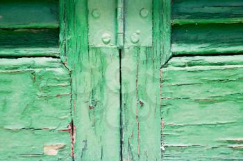 in the old wall a hinged window green wood and         rusty metal