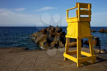 garbage basket yellow lifeguard chair cabin  in lanzarote  spain   rock stone sky cloud beach  water  musk pond  coastline and summer 
