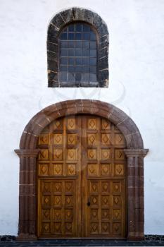 lanzarote  spain canarias brass brown knocker in a   closed wood  church door and white wall abstract 
