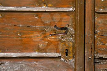 samarate  abstract   rusty brass brown knocker in a  door curch  closed wood lombardy italy  varese 