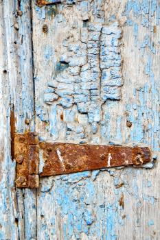 metal nail dirty     stripped paint in the brown   red wood door and rusty  knocker