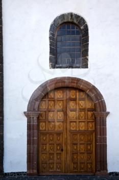 lanzarote  spain canarias brass brown knocker in a   closed wood  church door and white wall abstract 
