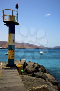 spain lighthouse and harbor pier boat in the blue sky   arrecife teguise lanzarote 
