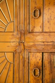 abstract cross   brass brown knocker in a   closed wood door venegono  varese italy