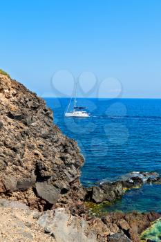in europe greece santorini island hill and rocks on the summertime beach 