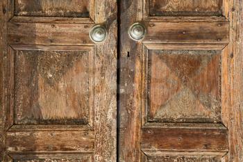 santo antonino abstract samarate   rusty brass brown knocker in a  door curch  closed wood lombardy italy  varese
