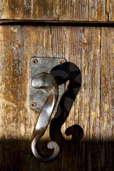 in  italy  patch lombardy    cross milan blur   abstract   rusty brass brown knocker  a  door curch  closed wood

