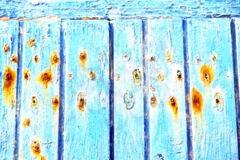 stripped paint in the blue wood door and rusty nail